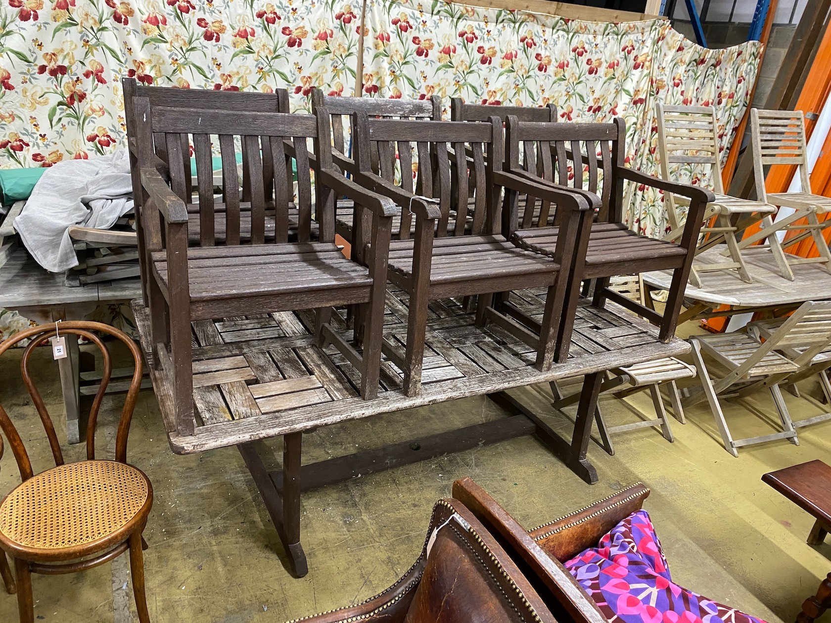 A rectangular weathered teak garden table, length 212cm, width 110cm, height 74cm and six elbow chairs by Alexander Rose